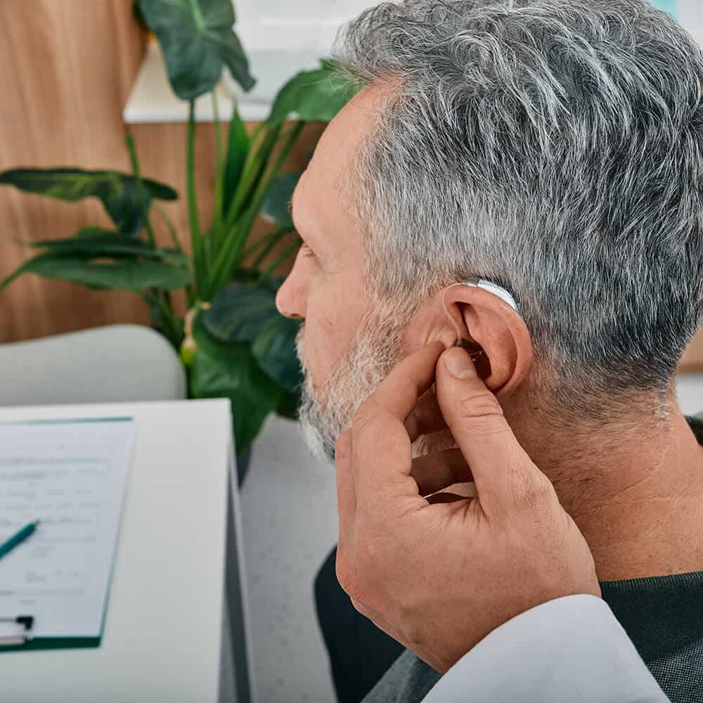 Man being fitted with hearing aid